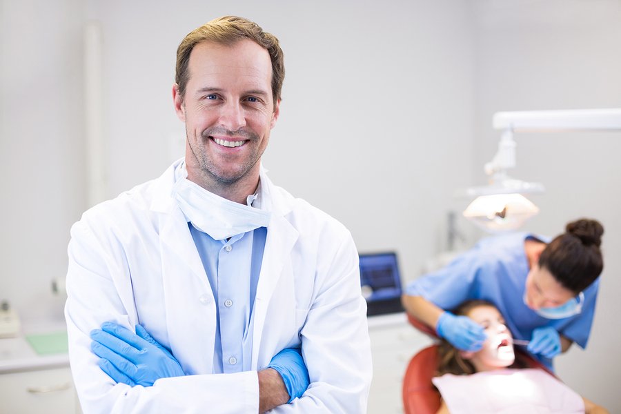 Portrait of dentist standing with arms crossed in clinic