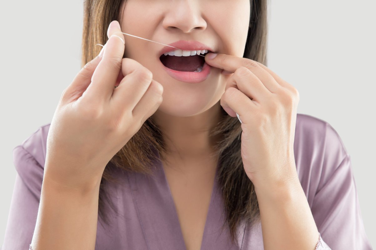 Asian Women In Satin Robes Cleaning Her Teeth Against Gray Background, Woman Flossing Teeth With Dental Floss, Oral Hygiene And Health Care