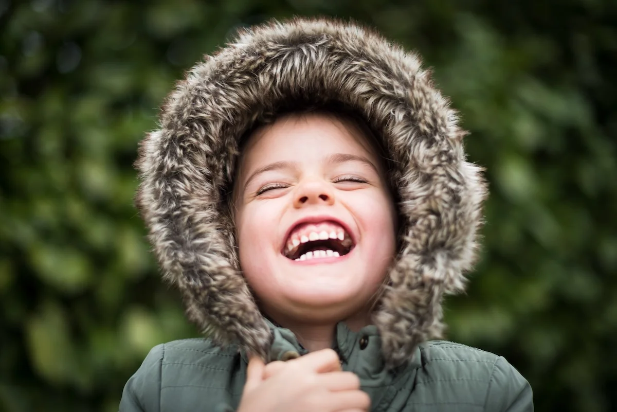 Laughing boy in hooded winter jacket