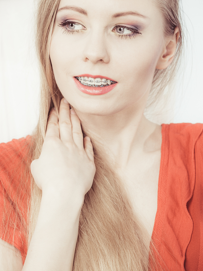 Elegant adult woman smile showing her white teeth with braces